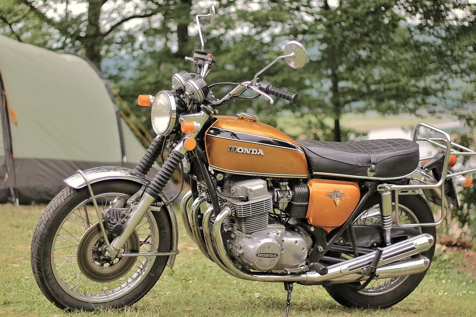 A gold 1970s Honda CB750 Four parked in a field