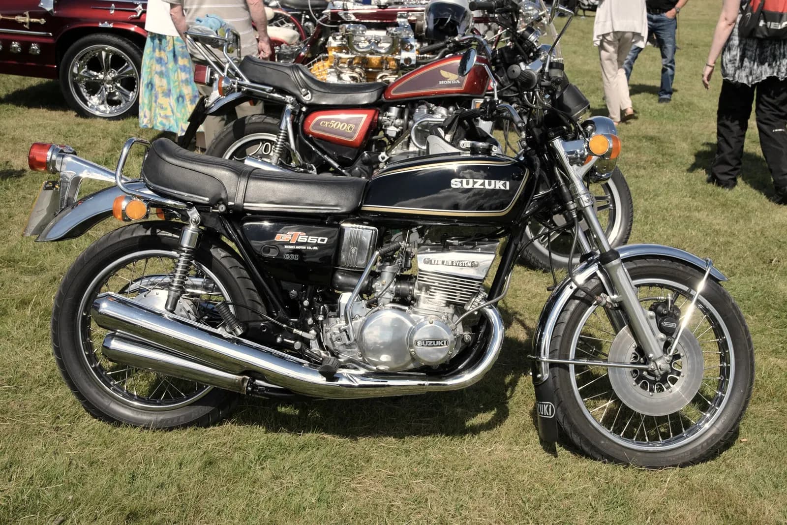 A 1976 Suzuki GT550 two-stroke parked among other classic bikes